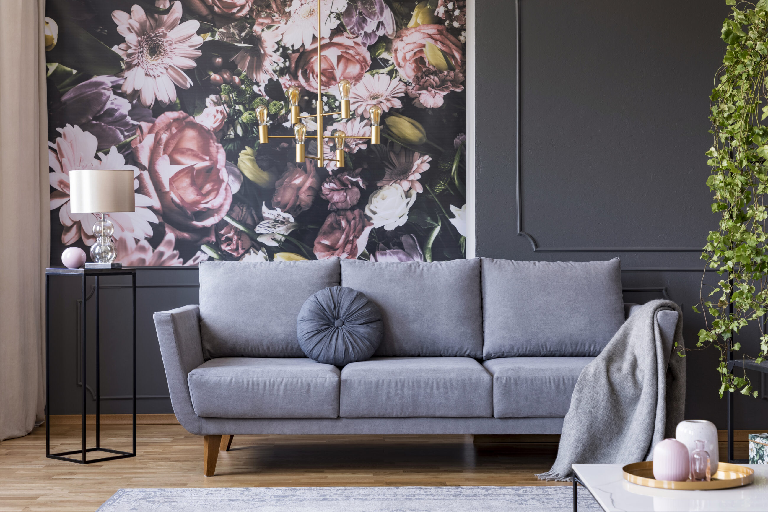 Real photo of dark living room interior with glass lamp, floral